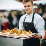 Catering personal som håller i en bricka med tilltugg